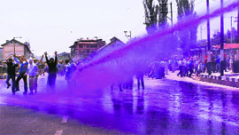 The police sprays coloured water on government employees during a protest in Srinagar on Monday.