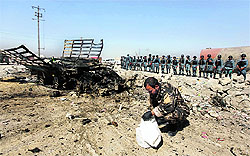 Afghan security personnel investigate the site of an attack on Kabul airport on Monday