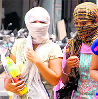 Heat before showers: Girls cover themselves to escape the sun in Amritsar on Tuesday. However, sudden showers brought some relief to the residents in the evening