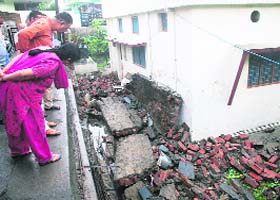 BJP MLA from Mussoorie Ganesh Joshi looks at a wall that collapsed due to heavy rain in the Rajpur area, Dehradun, on Tuesday