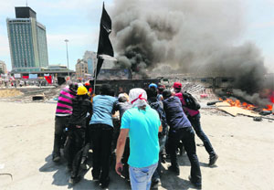 Protesters push a truck to use it to reinforce a barricade during clashes in Istanbul's Taksim Square on Tuesday. 