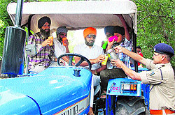 A CRPF officer distributes sweetened water on the martyrdom day of Guru Arjan Dev in Amritsar on Wednesday