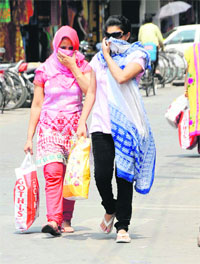 Two women cover their faces on a hot and humid day in Bathinda.