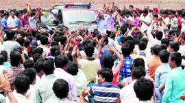 Protesting migrants surround a police vehicle in Ludhiana on Wednesday.