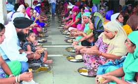 Devotees partake of langar at Gurdwara Dukh Nivaran Sahib on the martyrdom day of Guru Arjan Dev.