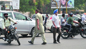 People cross the busy Ferozepur road in Ludhiana, putting their lives to danger.