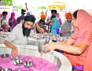 Sweetened water being served to devotees at the Golden Temple complex to mark the martyrdom day of Guru Arjan Dev in Amritsar on Wednesday.