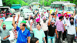 Pharmacists and class IV employees of the Health Department from rural areas block traffic at Cant Chowk in Amritsar on Thursday