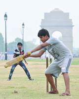 Children play cricket in the pleasant weather at Rajpath lawns in New Delhi on Thursday. Some parts of the city received rain showers which brings the mercury down. 