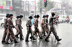 Unmindful of the rain, women constables head for their duty in Dehradun on Thursday