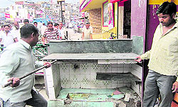 DMC staff breaks an encroachment on a footpath on Chakrata Road