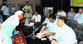 Deputy Commissioner J Ganesan (second from right) and ADC Shiv Prasad Sharma (to his left) listen to grievances of a woman at Mallekan in Sirsa.