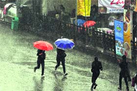 People run to safety during a downpour in Shimla on Thursday