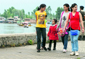 Tourists enjoy a walk on the banks of the Dal Lake in Srinagar on Thursday.