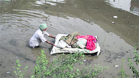 A vendor with his cart gets caught in the flooded Domoria railway underbridge.