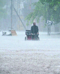 A rickshaw-puller wades through a flooded road in Ludhiana.
