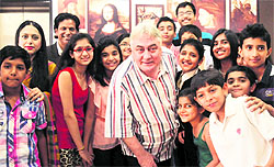 Barry John strikes a pose with children at the Chitkara International School
