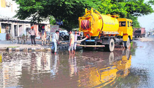 MC workers pump out rainwater accumulated on the Bathinda-Goniana road near the Rose Garden on Friday. 