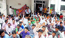 BJP workers hold a demonstration at the office of the Chief Engineer, PWD, in Dehradun on Friday against the bad condition of roads in Sahaspur