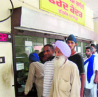 People waiting for their copy of jamabandi at the window of a farad kendra in Nawanshahr