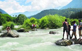 Rescue workers and locals search for the bodies of four youths who were drowned in the Lidder river near Nunwan in Pahalgam on Friday