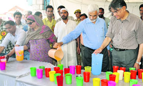 Prof Talat Ahmed, Vice-Chancellor, KU and Registrar Zaffer Reshi serve devotees at Hazratbal shrine on the occassion of Friday following Shab-e-Meraj in Srinagar.