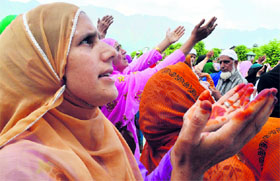 Devotees pray as an unseen custodian displays a holy relic, believed to be a hair from the Prophet Muhammad's beard, at Kashmir's main Hazratbal Shrine in Srinagar on Friday.