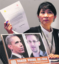 Two lawmakers in Hong Kong said on Friday that they had written to us President Barack Obama to try to persuade him not to bring charges against the former US intelligence contractor Edward Snowden. Pro-democractic legislator Claudia Mo holds the letter which will be sent to Obama during a news conference in Hong Kong on Friday. 