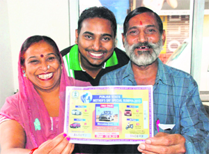 Shashi, who won a Mercedes car in a lottery, along with his wife and son, in Dera Bassi on Saturday.