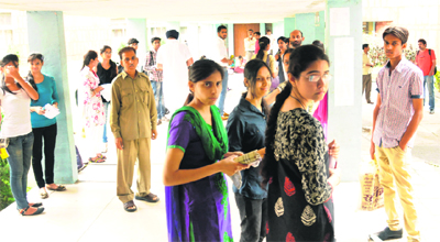 Candidates wait before the entrance test outside an examination centre at Panjab University on Saturday.