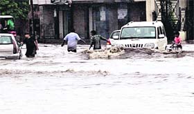 Commuters face a tough time as the roads get flooded with rainwater in Jalandhar on Saturday