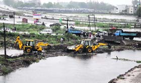 JCB machines deployed to raise bundhs across the Wadala Drain, which had a breach that caused flooding in Bhagat Singh Colony in Jalandhar on Saturday