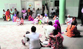 In absence of proper seating arrangement, patients squat on the floor outside the ultrasound centre of the Civil Hospital.