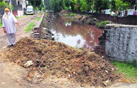 A resident of Bhagat Singh Colony shows the weak side of Kala Sanghia drain where breach might occur any time