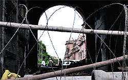 Barbed wires and (below) construction material used to block the main gate of the palace at Mubarak Mandi in Jammu