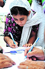 A child takes part in the signature campaign against 1984 riots accused in Jammu on Sunday