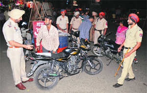 Policemen check two-wheelers during a naka in Ludhiana on Sunday.