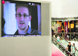 Edward Snowden, a former contractor at the National Security Agency (NSA), is seen during news broadcast on a screen at a shopping mall in Hong Kong on Sunday. He is accused of having leaked revelations of US electronic surveillance and is now believed to be holed up in Hong Kong.