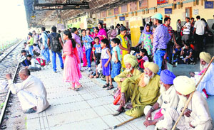 Passengers wait on a platform at the railway station in Chandigarh on Monday.
