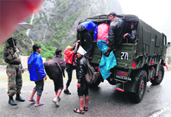 Army men rescue stranded pilgrims from the Gobind Ghat area of Joshimath, Chamoli, on Monday; and (right) 