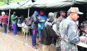 Pilgrims and tourists being provided food at a kitchen set up by the Army at Joshimath on Monday.