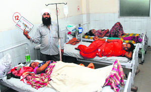 Balwinder Singh tries to fan his newborn grandchildren at the Civil Hospital in Jalandhar on Monday. 