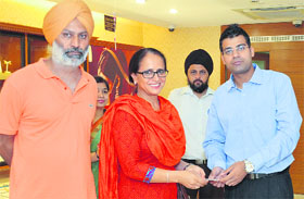 Mandeep Singh (R) ABM, Titan Industries Limited giving away the prize to the winners of Swiss Escape.