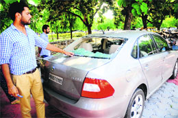 A student shows a car which was damaged in the attack on the PUSU leader at the PU in Chandigarh on Tuesday.