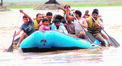 Policemen rescue jhhugi dwellers of the Bairagi camp as the swirling waters of the Ganga, which is flowing two metres above the danger level, entered their houses in Haridwar on Tuesday. Tribune photo: Rameshwar Gaur