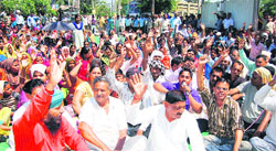 Congress councillor Des Raj Jassal and his supporters hold a protest at the auction site at Maqsudan in Jalandhar on Tuesday. Tribune photo: Malkiat Singh