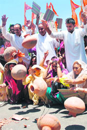 Shiv Sena activists hold a protest against the Electricity and PHE Departments in Jammu on Tuesday.