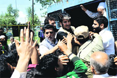 The police takes Hurriyat leader Shabbir Ahmad Shah into custody during a protest against human rights violations in Srinagar on Tuesday. 