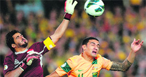 Tim Cahill tries to head over the goalkeeper Noor Sabri Abbasi during their World Cup qualifier on Monday. 