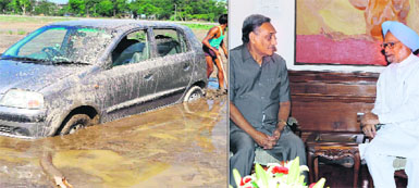 A man tries to take out a car from flood waters in Haridwar on Wednesday; and (right) Chief Minister Vijay Bahuguna briefs Prime Minister Manmohan Singh on the natural disaster in the state in New Delhi on Wednesday. 